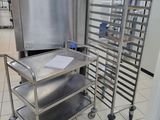 a metal cart with a bunch of trays on it in a kitchen