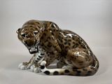 a figurine of a leopard sitting on the ground