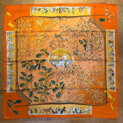 an orange silk scarf with a picture of birds and flowers on it