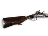 un vieux fusil avec une poignée en bois sur fond blanc