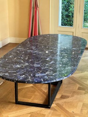 une table en marbre avec un piètement noir dans une pièce