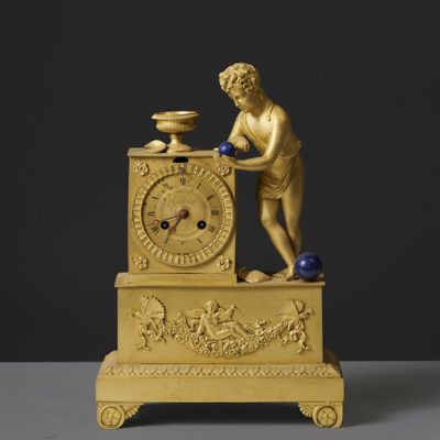 une horloge en or surmontée d'une statue