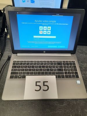 un ordinateur portable posé sur une table sur laquelle figure un numéro