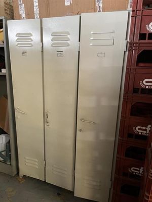 plusieurs casiers métalliques dans un entrepôt, avec des cartons empilés par terre
