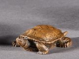 deux petites figurines représentant une tortue sur un fond gris