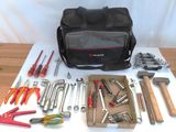 un sac d'outils posé sur une table à côté d'une paire de pinces