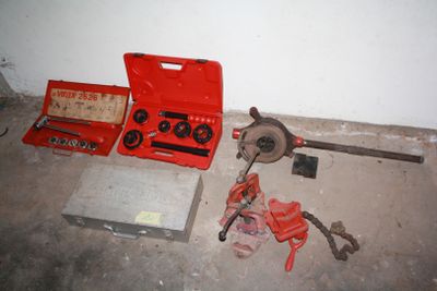a red tool box sitting on the floor next to tools
