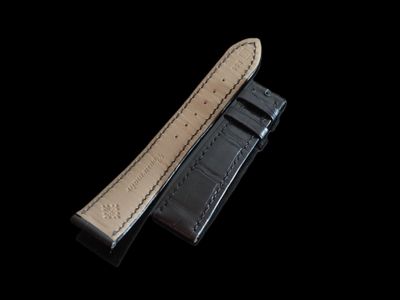 deux morceaux de cuir noir avec des coutures blanches sur fond noir