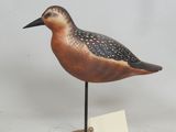 un petit oiseau posé sur un socle en bois