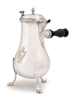 an antique silver coffee pot with a black handle on a stand