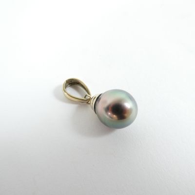 a close up of a pearl pendant on a white surface
