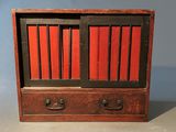 une image représentant un petit meuble en bois aux portes rouges et noires