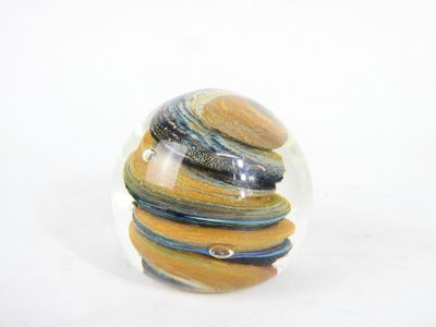 a glass ball with a marble inside of it on a white surface