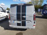 a white van with blue stripes parked in a parking lot