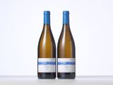 two bottles of white wine sitting on top of a table
