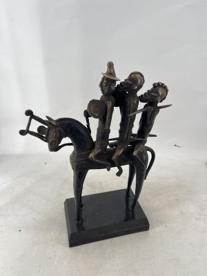 bronze figurine of a man on a horse with three men riding on it