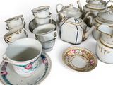 many cups and saucers that are sitting on the table