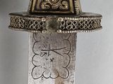 a silver knife with a gold decoration on it