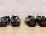 three pairs of black shoes are lined up on a wooden table