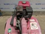 a pink lawn mower with a no parking sign on it