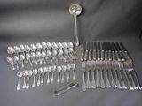 many spoons and forks laid out on a table