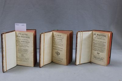 trois livres ouverts posés les uns à côté des autres sur une table