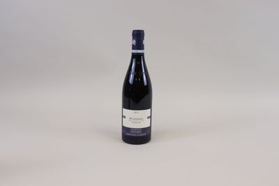 la bouteille de vin est posée sur une surface blanche