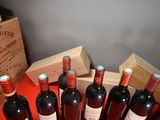 several bottles of wine are lined up on a red table