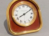 une petite horloge avec des chiffres romains