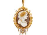 un pendentif camée plaqué or représentant le visage d'une femme et orné de perles