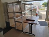 a room with a desk and shelves in it