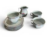 several cups and saucers sitting on top of each other on a white surface