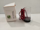 a box and a glass on a table with a red cord