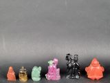 five figurines of different colors on a black surface
