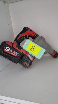 a cordless drill on the floor in the corner of the room
