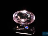 une image représentant un diamant rose posé sur une surface noire