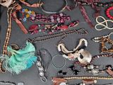many different necklaces and bracelets laid out on a table