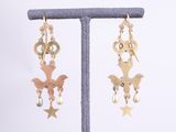 gold plated bird and star dangle earrings on a stand