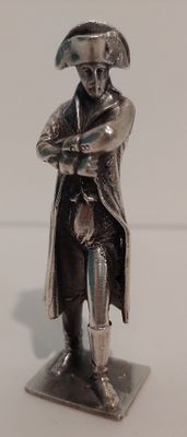 statue d'un homme coiffé d'un chapeau et portant une épée, posée sur une surface blanche