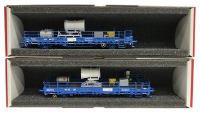 deux wagons bleus dans une boîte posée sur une surface blanche