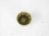 a small green cup sitting on a white surface