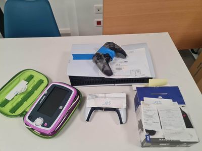 une valise rose et verte posée sur une table, à côté d'une chaise bleue