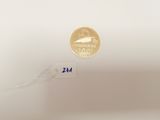 a gold coin on a white surface next to a string