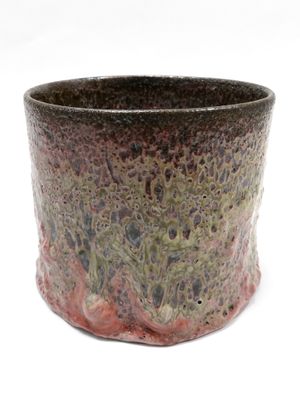 un gros plan d'une tasse posée sur une surface blanche