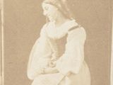 a sepia photograph of a woman sitting on a chair