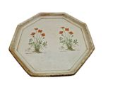 a plate with two flowers on it on a white background