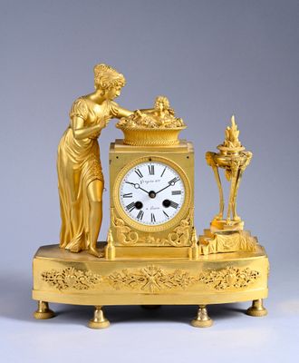 a gold clock with a statue on top of it