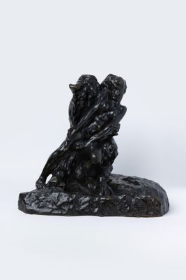 une photo représentant une statue de deux personnes assises sur un rocher