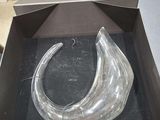 a clear glass object in a box on a table