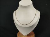 necklace on a wooden stand on a black background